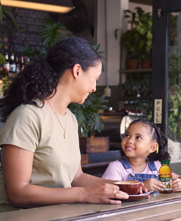 Mother and young daughter eating lunch and enjoying TreeTop apple juice