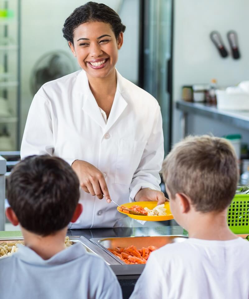 Lunch lady serving kids school lunch